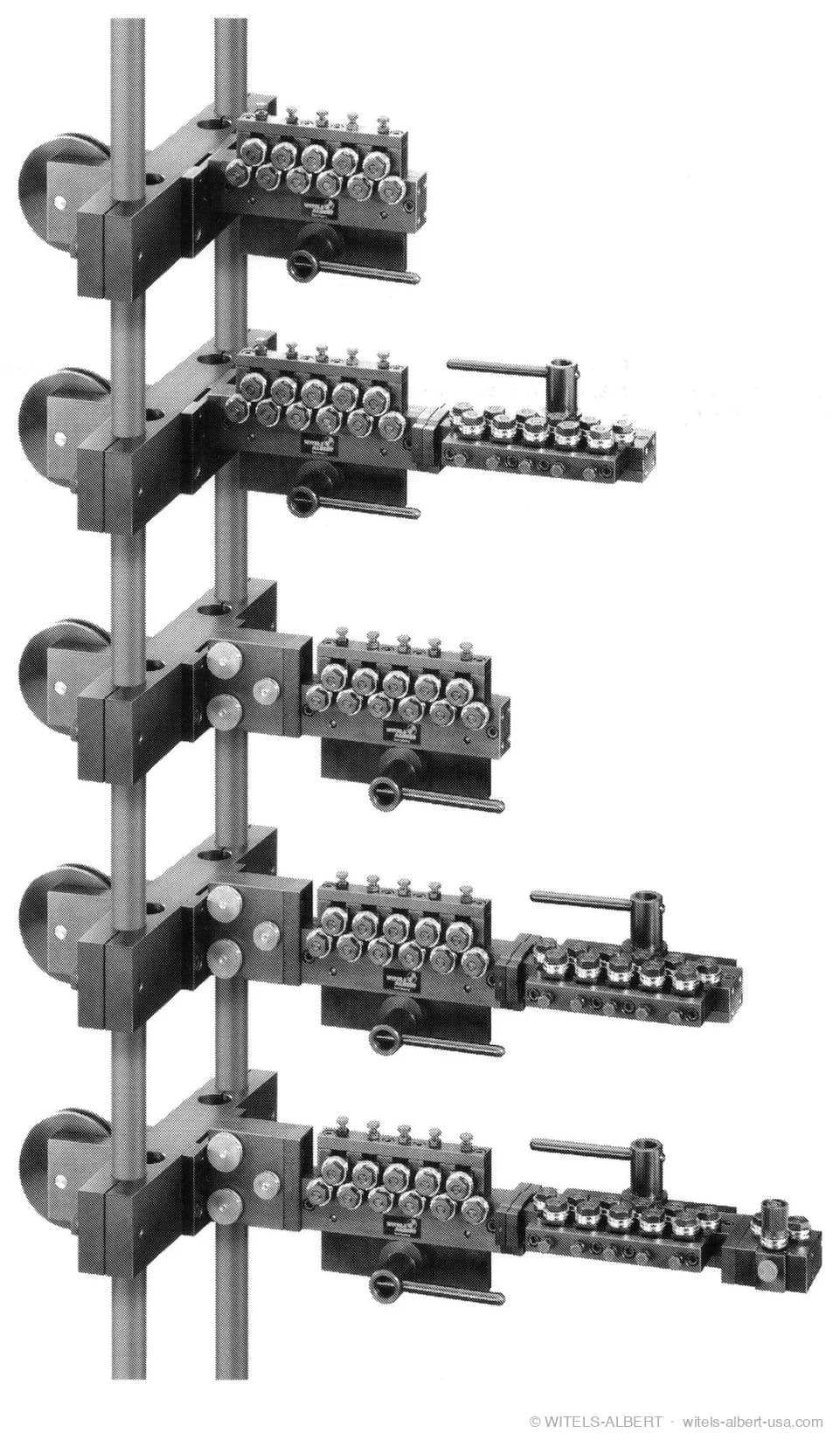 Photograph of five WITELS roll-type straightener units of increasing size mounted on two vertical posts, each with adjustable straightening rolls and a clamping lever.