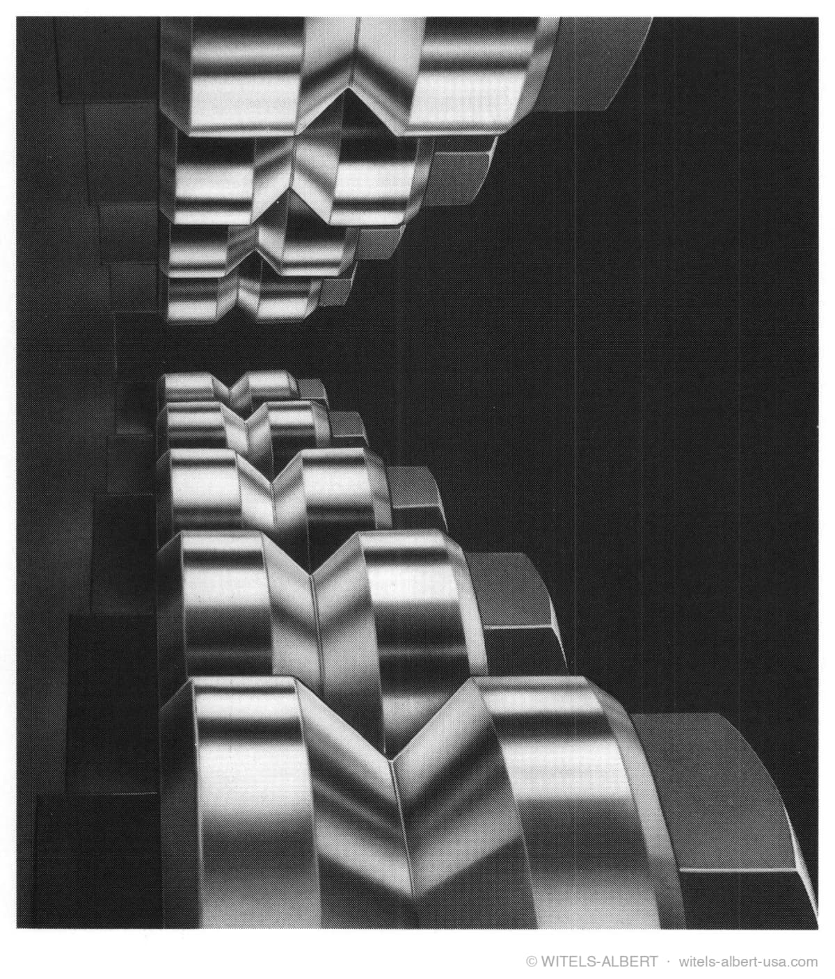 Close-up photograph of grooved straightening rolls arranged in two parallel, mutually offset rows inside a roll-type straightener.